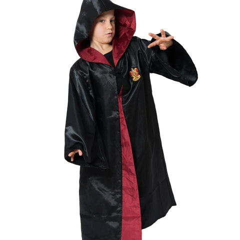 Child wearing a black and red harry potter robe with a school crest on a white background